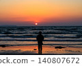 A silhouette of a woman gazing at a beautiful, bright red sunset on Fukuma Beach in Fukuoka Prefecture. A silhouette of a woman gazing at a beautiful, bright red sunset on Fukuma Beach in Fukuoka Prefecture. 140807672
