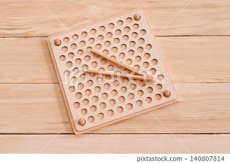 Wooden sorting board for playing with colorful balls on the table. Montessori Toy Wooden sorting board for playing with colorful balls on the table. Montessori Toy 140807814