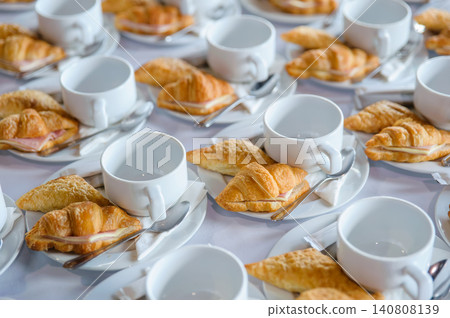 many line of croissant on a dish with empty coffee cups on the table ready to served for tea break in business conference many line of croissant on a dish with empty coffee cups on the table ready to served for tea break in business conference 140808139