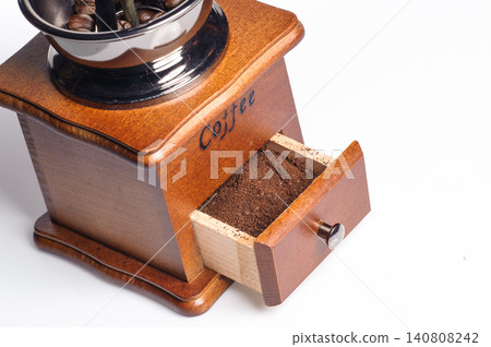 grounded coffee from the grinding machine with some coffee beans before grinded 140808242