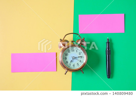 Vintage alarm clock with color card on color background. 140809480