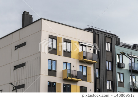 Modern residential building facade with geometric balconies, brick accent walls, and contemporary apartment block design. Modern residential building facade with geometric balconies, brick accent walls, and contemporary apartment block design. 140809512