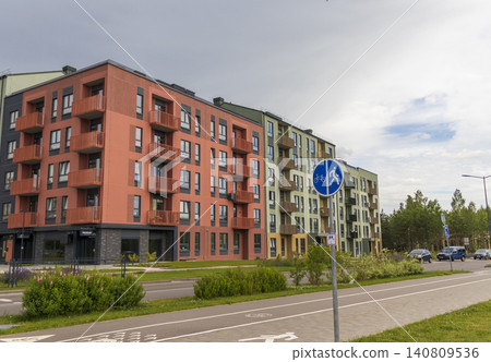 MINSK, BELARUS - JUNE 24, 2026: Modern scandinavian-style cityhouses and contemporary apartment block architecture in the suburban residential complex Zelena Gavan near Kolodishchi on a cloudy day. 140809536