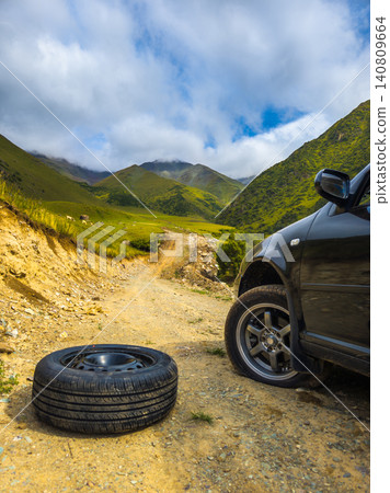 Black Car with Flat Tire on Dirt Road in Kyrgyzstan Black Car with Flat Tire on Dirt Road in Kyrgyzstan 140809664