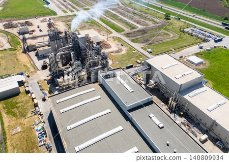 Aerial shot of a manufacturing facility with smoking chimney during production. Aerial shot of a manufacturing facility with smoking chimney during production. 140809934