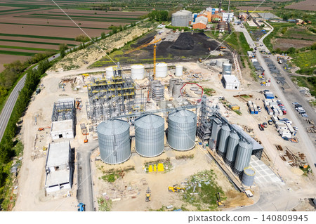 Construction site of a modern agricultural complex with silos, grain elevator and storage terminal. Aerial view. Construction site of a modern agricultural complex with silos, grain elevator and storage terminal. Aerial view. 140809945