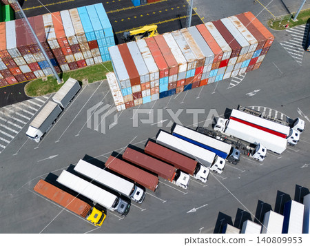 Aerial view of a logistics hub with multicolored shipping containers and trucks 140809953