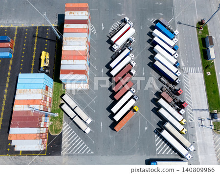 Aerial view of a logistics hub with multicolored shipping containers and trucks 140809966
