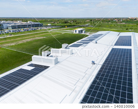 Aerial view of a modern factory with solar panels and energy storages on the roof. Aerial view of a modern factory with solar panels and energy storages on the roof. 140810006