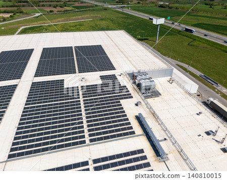 Aerial view of a modern logistics center with solar panels on the roof. Aerial view of a modern logistics center with solar panels on the roof. 140810015