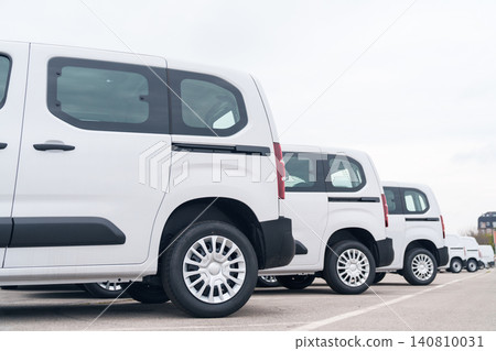 White delivery vans are parked in rows. Commercial fleet of vehicles. 140810031
