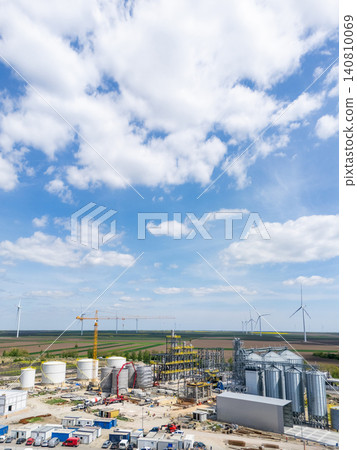 Construction of a modern agricultural grain terminal with wind turbines on the horizon. Construction of a modern agricultural grain terminal with wind turbines on the horizon. 140810069