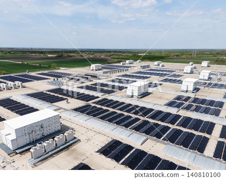 Aerial view of a modern factory with solar panels and energy storages on the roof. Aerial view of a modern factory with solar panels and energy storages on the roof. 140810100