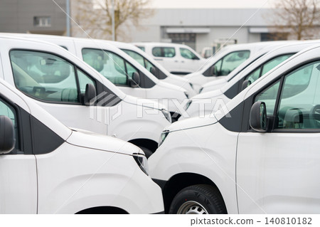 White delivery vans are parked in rows. Commercial fleet of vehicles. White delivery vans are parked in rows. Commercial fleet of vehicles. 140810182