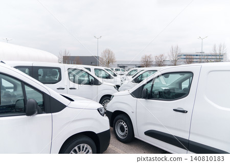 White delivery vans are parked in rows. Commercial fleet of vehicles. White delivery vans are parked in rows. Commercial fleet of vehicles. 140810183