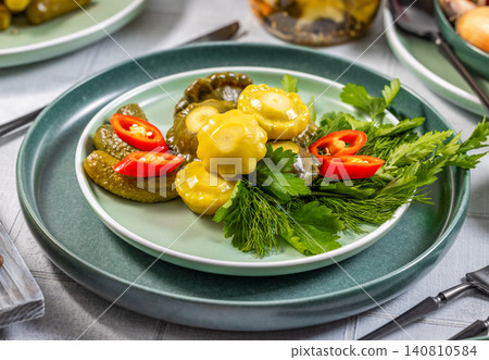 Pickled pattypan squash and gherkins with fresh herbs and chili pepper Pickled pattypan squash and gherkins with fresh herbs and chili pepper 140810584