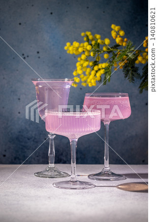 Pink cocktails with mimosa flowers on a table Pink cocktails with mimosa flowers on a table 140810621