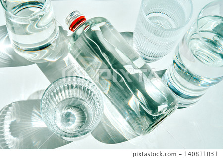 Glass bottle with sparkling water and drinking glasses Glass bottle with sparkling water and drinking glasses 140811031