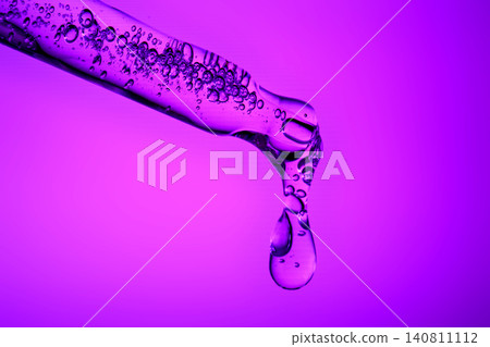 Skincare serum dropper with purple liquid dropping Skincare serum dropper with purple liquid dropping 140811112