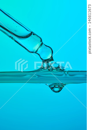 Pipette dripping serum creating abstract liquid surface Pipette dripping serum creating abstract liquid surface 140811673