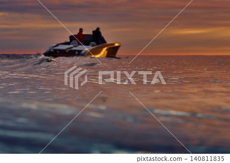 Incredible reflection on the glossy side of a modern motorboat at sunset, the Gulf of Finland, magic reflections on water surface Incredible reflection on the glossy side of a modern motorboat at sunset, the Gulf of Finland, magic reflections on water surface 140811835