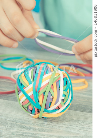 Preschooler hands with ball of rubber bands or erasers Preschooler hands with ball of rubber bands or erasers 140811906