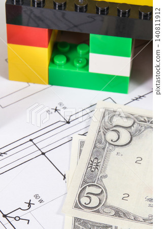 Small house made of toy blocks, housing plan with electric installation and dollar banknotes Small house made of toy blocks, housing plan with electric installation and dollar banknotes 140811912