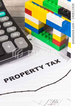 House made of toy blocks, calculator and rising graph showing property tax increases 140811916