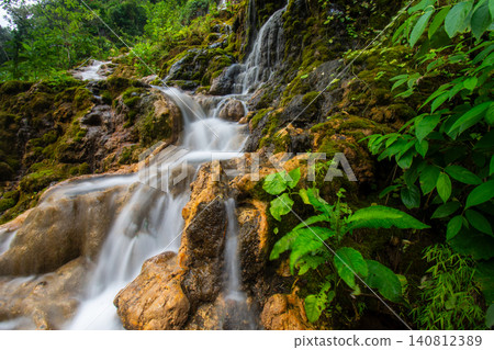 Beautiful silk effect waterfall flowing down mossy rock cliffs at Goa Tetes Lumajang Indonesia Beautiful silk effect waterfall flowing down mossy rock cliffs at Goa Tetes Lumajang Indonesia 140812389