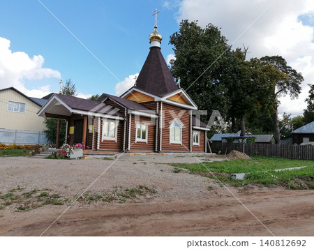wooden orthodox church with golden dome stands on dirt site wooden orthodox church with golden dome stands on dirt site 140812692