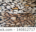 dense wall of chopped wooden logs of various sizes and shades 140812717