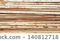 many thin wooden slats with bark arranged horizontally in rows 140812718