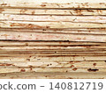 horizontal stack of wooden planks with knots and bark close up 140812719