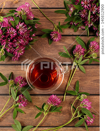 Medicinal herbal tea or red clover infusion in a glass cup with flowers, alternative traditional medicine concept, estrogen source, menopause remedy, green pharmacy advertisement, Medicinal herbal tea or red clover infusion in a glass cup with flowers, alternative traditional medicine concept, estrogen source, menopause remedy, green pharmacy advertisement, 140812900