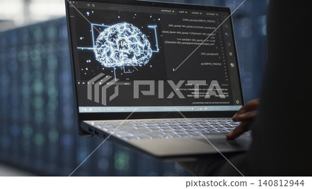 Computer scientist uses laptop-based deep learning tools in a server room to improve AI operations and system efficiency. Computer scientist uses laptop-based deep learning tools in a server room to improve AI operations and system efficiency. 140812944