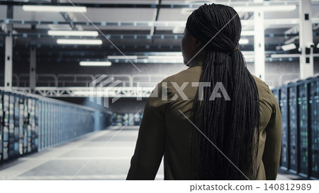 System administrator oversees large scale IT equipment in a data center to maintain seamless operations. 140812989