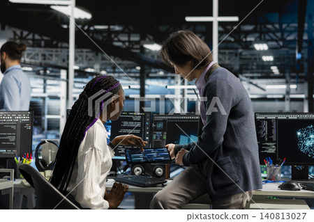 Man uses an AI language model assistant in a server hub to handle infrastructure maintenance. Man uses an AI language model assistant in a server hub to handle infrastructure maintenance. 140813027