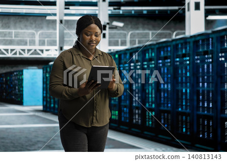 Cheerful IT specialist smiles while reviewing stable systems in a data center after improved performance and completed server operations. 140813143