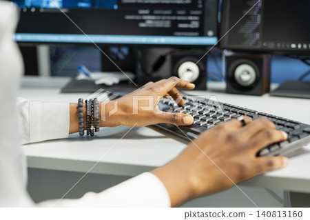 Computer scientist works with desktop computer in a data center to support data processing, analytics, and storage infrastructure. Computer scientist works with desktop computer in a data center to support data processing, analytics, and storage infrastructure. 140813160