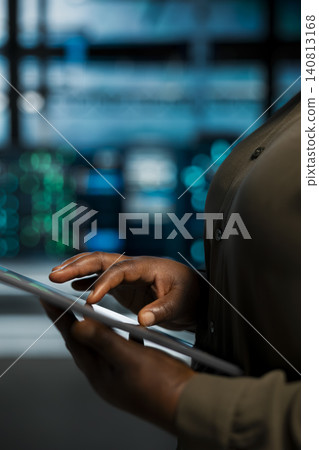 Data center technician uses a digital tablet in a data center to troubleshoot backend operations and resolve system crashes. Data center technician uses a digital tablet in a data center to troubleshoot backend operations and resolve system crashes. 140813168