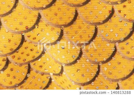 Yellow fabric in scales gray macro background with fold. Yellow fabric in scales gray macro background with fold. 140813288