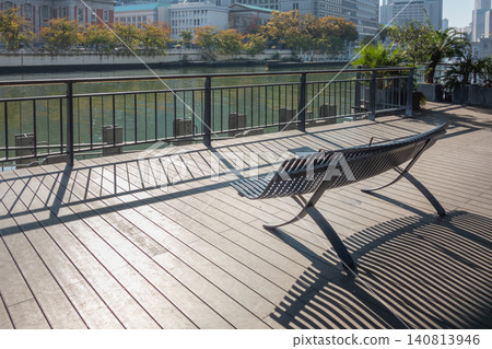 A wooden deck and benches along the river: a respite in the city. 140813946