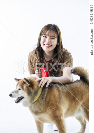 一隻柴犬和一位年輕女子，背景為白色。 140814655