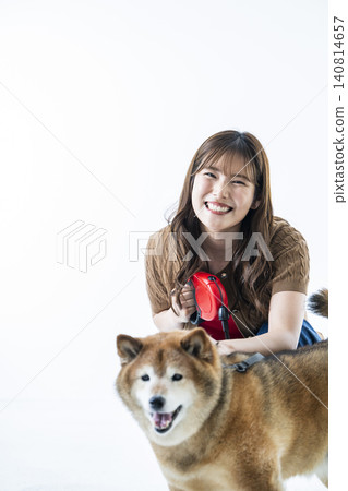 A Shiba Inu and a young woman against a white background. 140814657