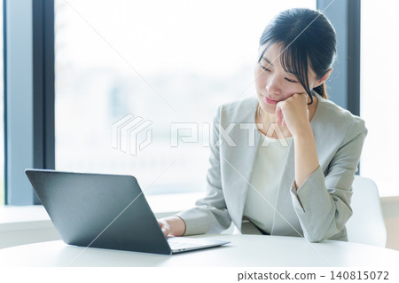 一位表情陰鬱的女商人正在使用電腦。 一位表情陰鬱的女商人正在使用電腦。 140815072