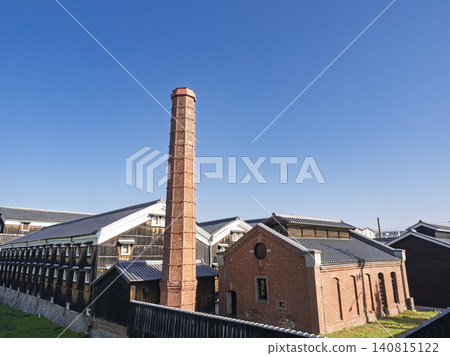 A sake brewery that embodies tradition, its red bricks standing out against the blue sky. A sake brewery that embodies tradition, its red bricks standing out against the blue sky. 140815122