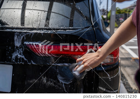 A man washing the taillights of his car. A man washing the taillights of his car. 140815230