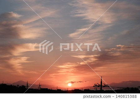 A beautiful sunrise with a vibrant sun rising from the horizon and clouds of morning glow spreading across the sky. A beautiful sunrise with a vibrant sun rising from the horizon and clouds of morning glow spreading across the sky. 140815388