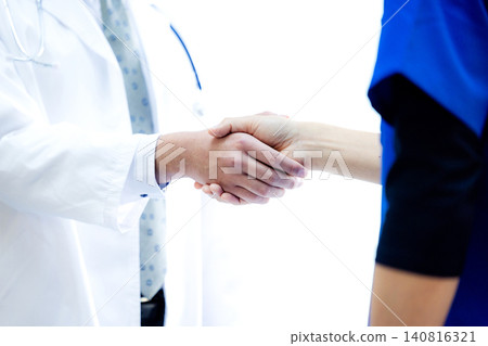 一位醫生和一位身穿白大褂的商人在醫院握手的醫學形象 140816321