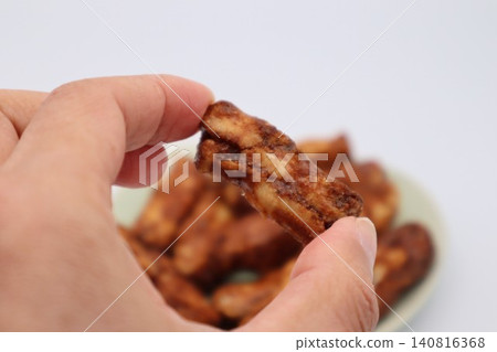 A person holding karinto (a type of Japanese snack). A person holding karinto (a type of Japanese snack). 140816368